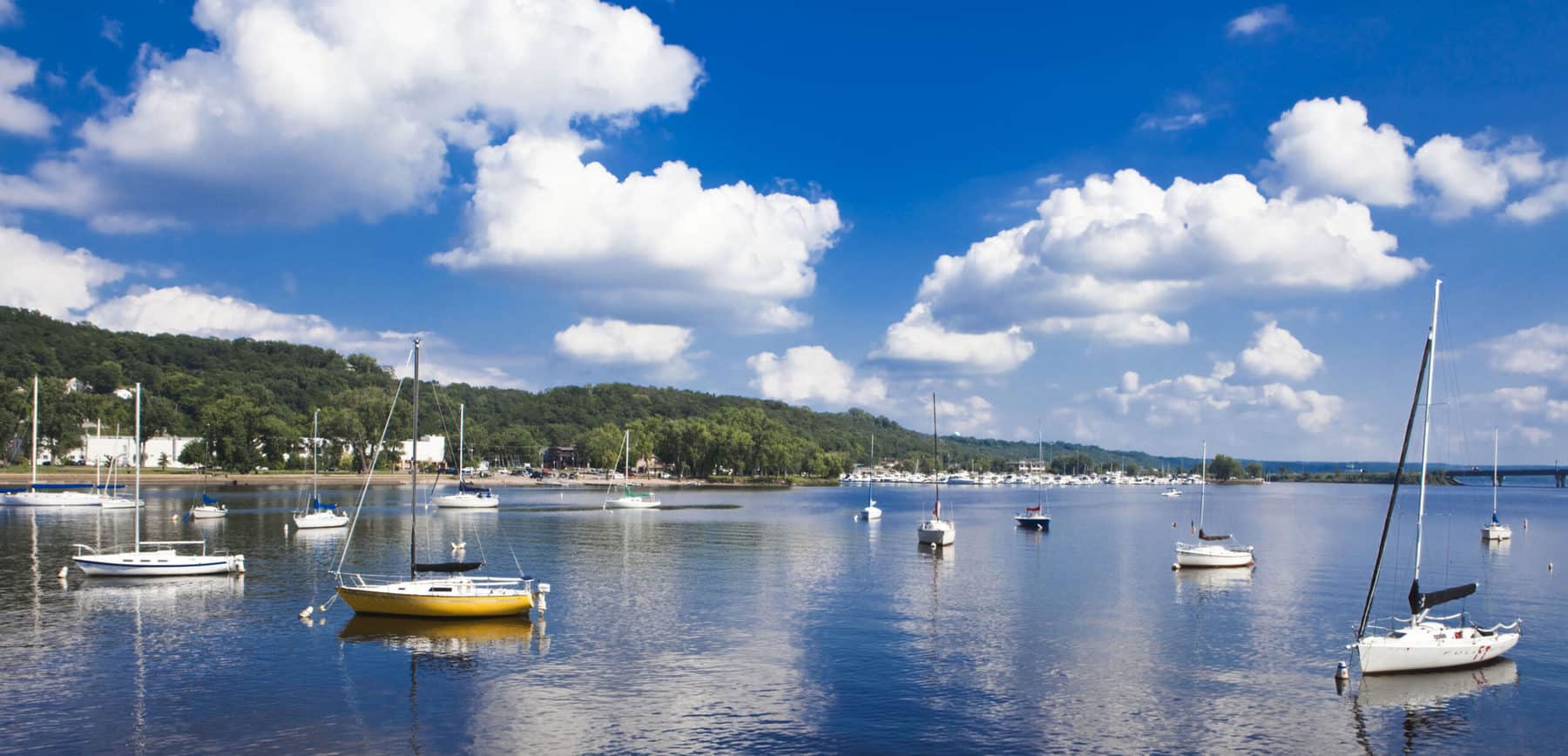 Sailboats anchored on the St. Croix River near Hudson, Wisconsin, on a sunny day with blue skies.