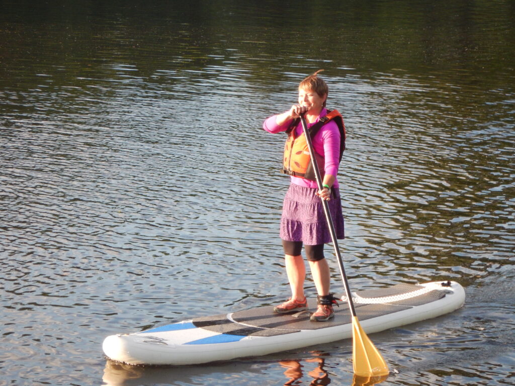 A woman stands on a paddleboard on the St. Croix River. Photo by David Robishaw.