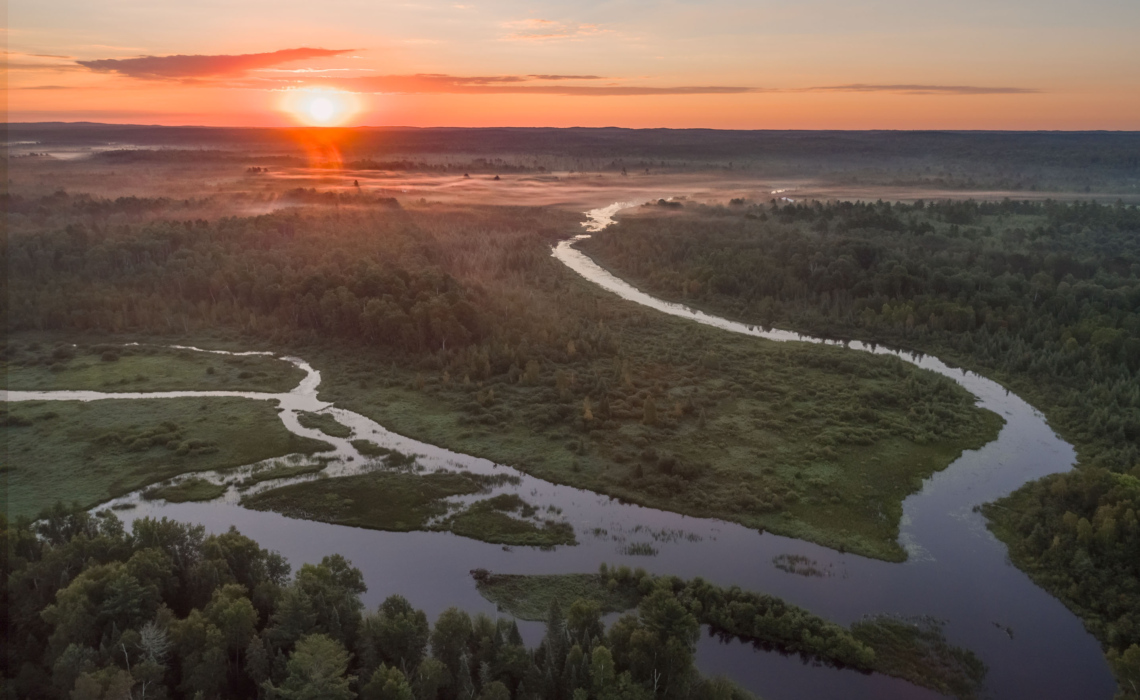 A drone image captures a sunrise over the Phipps Flowage of the Namekagon River