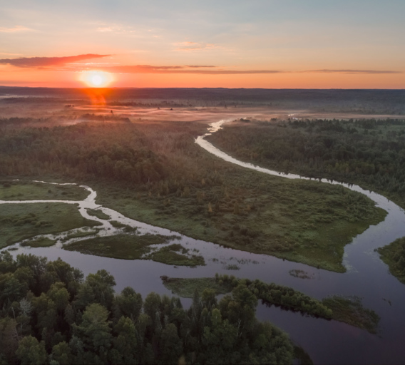 A drone image captures a sunrise over the Phipps Flowage of the Namekagon River