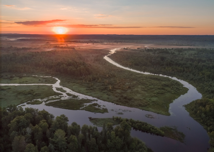 A drone image captures a sunrise over the Phipps Flowage of the Namekagon River