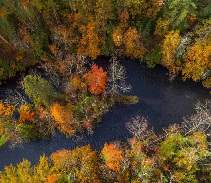 A drone shot of the Namekagon River shows vibrant fall colors on the trees