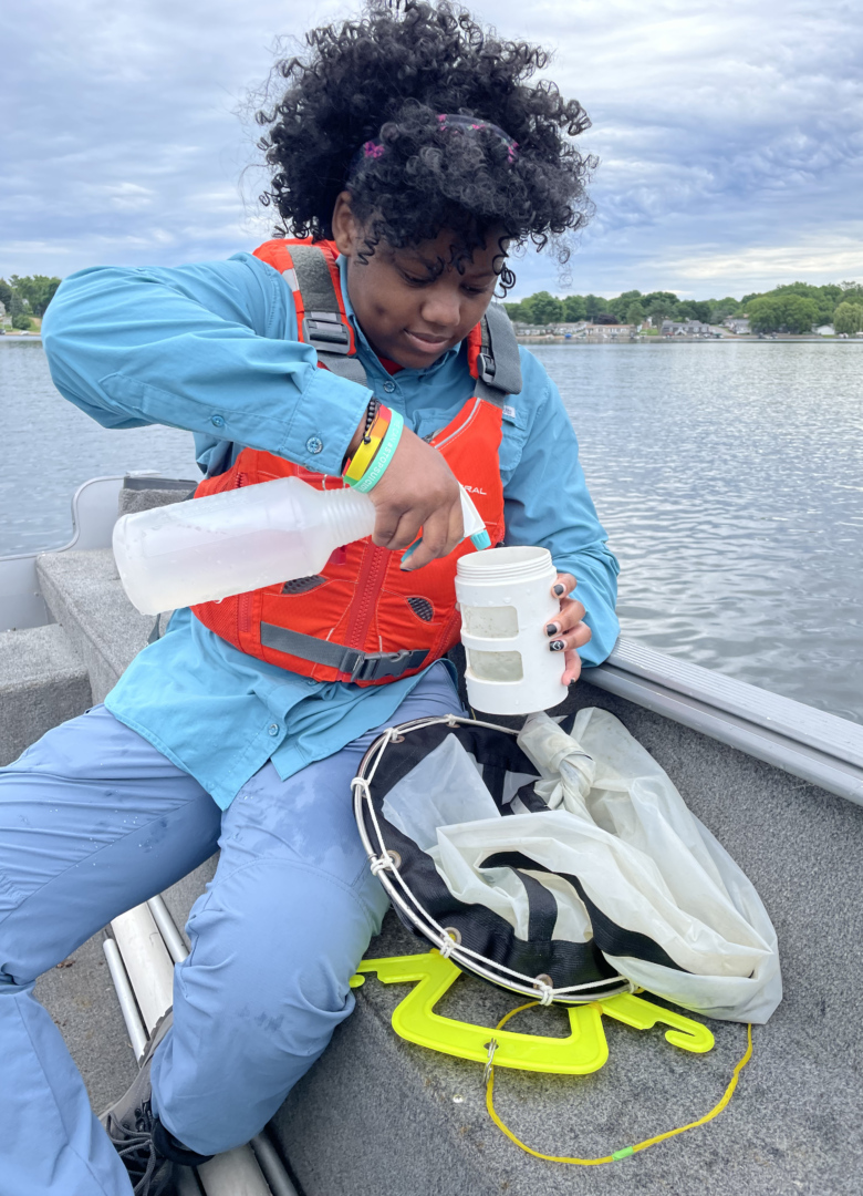 Wild Rivers Conservancy Summer Intern Ajoi takes a water sample from a boat