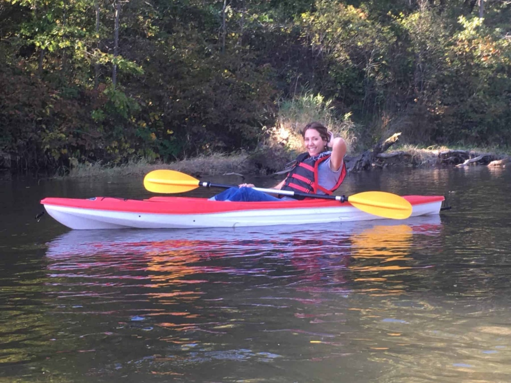Andrea Jorgenson, Wild Rivers Conservancy Board member, smiling and sitting in a kayak with a paddle on the St. Croix River.