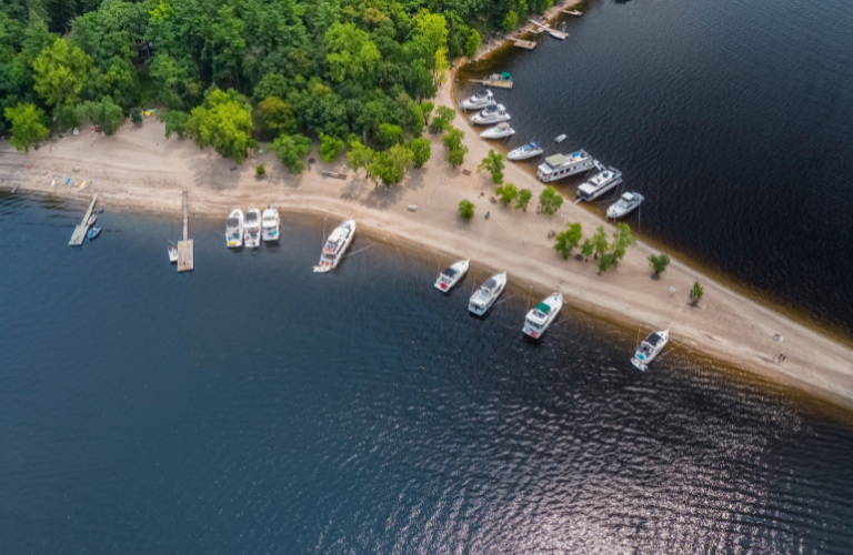 A drone shot show large river boats parked on a sandbar on the St. Croix River. PC Craig Blacklock