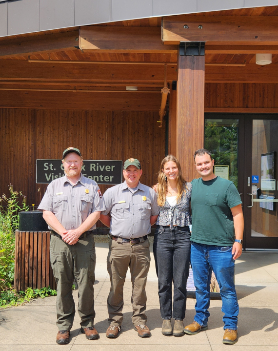 Summer interns pose with 2 NPS park rangers in front of the St. Croix Falls Visitor Center
