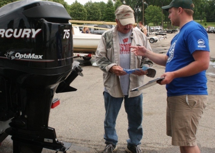 A watercraft inspector volunteer gives instructions to boater.