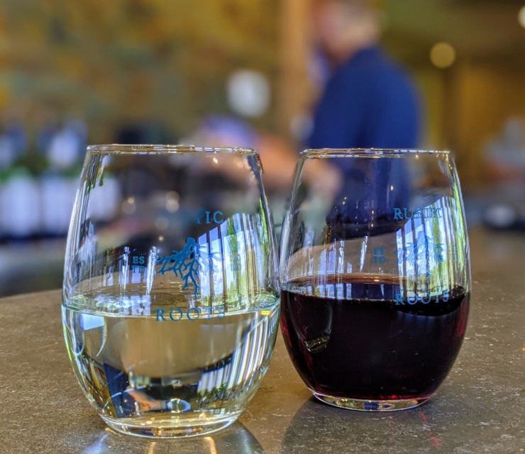 Two wine glasses sit on a bar top